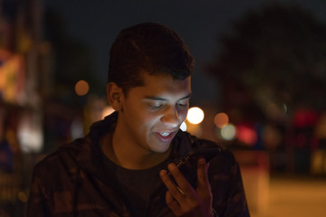 Man looks at his smart phone at night.