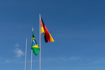 Brazil and Germany flags against blue sky