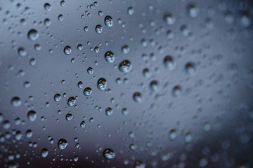 Rain drops on glass window at night.
