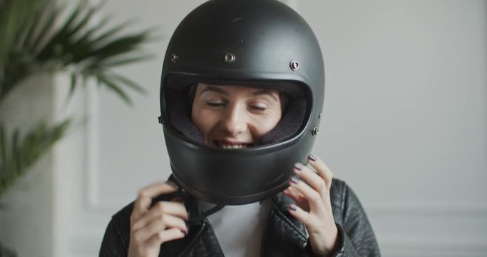 woman taking off retro helmet in bright room