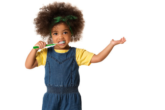 A little cute african american girl brushing her teeth, isolated