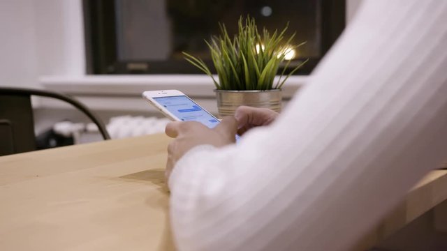 Young Person Leaning on a Desk While Texting