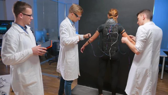 Robotics engineers connecting wired to exoskeleton
