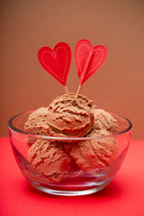Chocolate Ice Cream in a Glass Bowl on a Brown Background