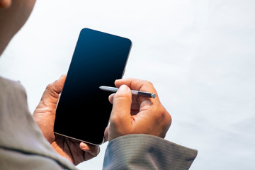 Hand holding smartphone with mobile pen. Digital technology for business and marketing.