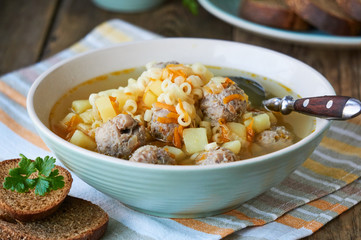 Soup with meatballs, pasta anellini and vegetables in a bowl