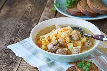 Soup with meatballs, pasta anellini and vegetables in a bowl