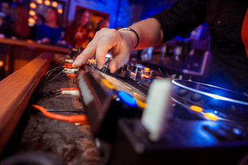 Dj mixes the track in the nightclub at party