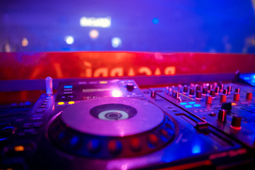 Naklejka na ściany i meble control DJ for mixing music with blurred people dancing at party in nightclub