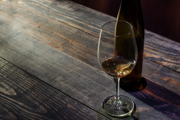 Wine on wooden table next to bottle