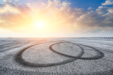 Fototapeta premium Asphalt road pavement and dramatic sky at sunset