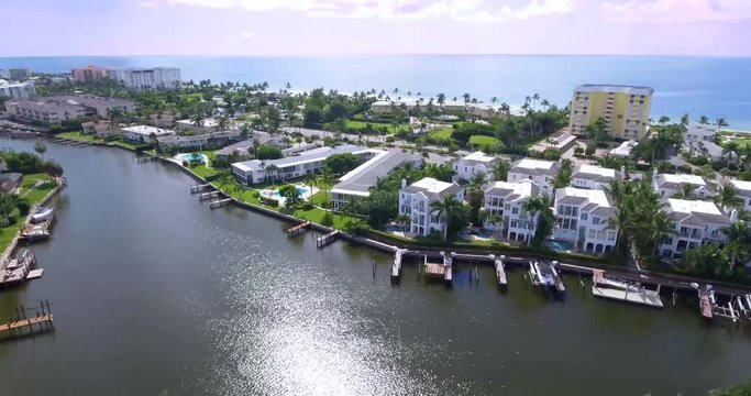 Panning aerial drone skyscape of the Gulf of Mexico in Naples Florida. The shot also reveals a canal/bay in the forground. Beautiful scenery and lifestyle.