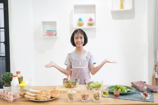 Asian little girl cooks in the kitchen at home