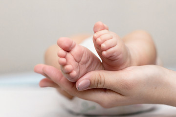 Mother is giving a massage to her newborn son