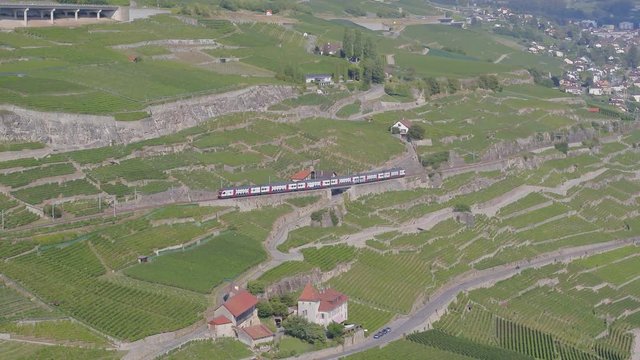 Aerial shot following Swiss train through Lavaux vineyard, Switzerland