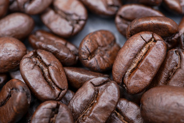 Macro shot of whole bean organic smooth medium dark roast coffee from Sumatra on natural stone background