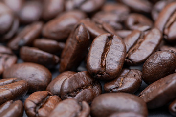 Macro shot of whole bean organic smooth medium dark roast coffee from Sumatra on natural stone background