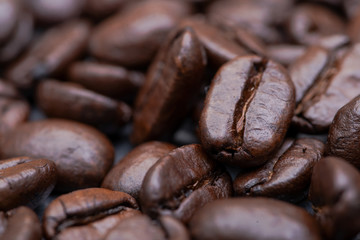 Macro shot of whole bean organic smooth medium dark roast coffee from Sumatra on natural stone background