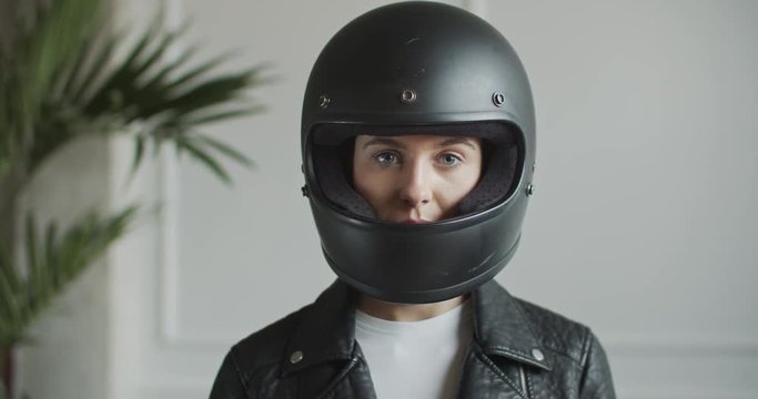 woman putting on retro helmet in bright room