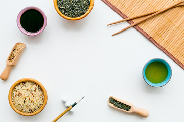 Chinese traditional symbols concept. Tea, rice, hieroglyph love, bambootabe mat, chopsticks, soy sause on white background top view frame copy space