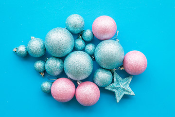 Toys for New Year tree 2019 background. Blue and pink balls and stars on blue background top view