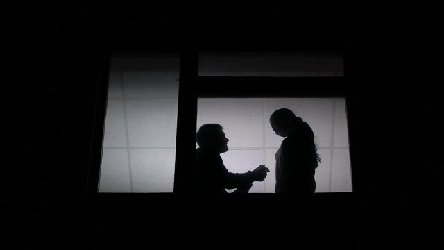 Boyfriend proposing girlfriend to marry him, engagement at home, silhouette