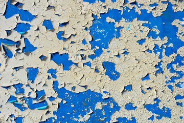 light coloured blue peeling paint on the old rough concrete surface