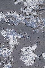 grey peeling paint on the old rough concrete surface