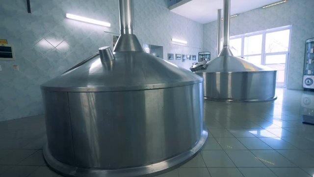 Two massive canisters placed in a hall of a brewery factory