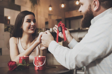 Bearded man gives a present to beautiful girl