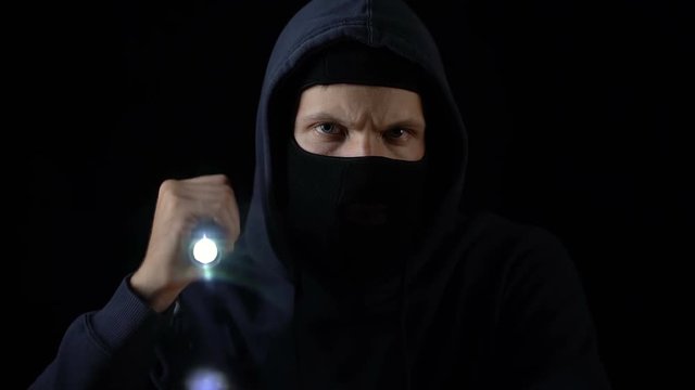 Criminal in balaclava flashing torch to break lock, forced entry, breaking in