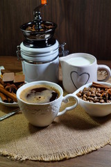 Aromatic hot coffee in a cup and in beans, spices and chocolate
