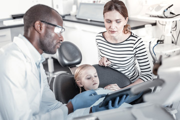 Concentrated female person sitting near her daughter