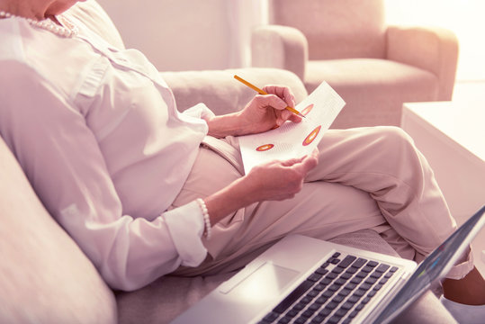 Elder lady sitting on the couch checking data