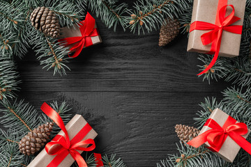 Christmas card with gifts and fir branches on a dark wooden rustic background, place for text. Xmas...