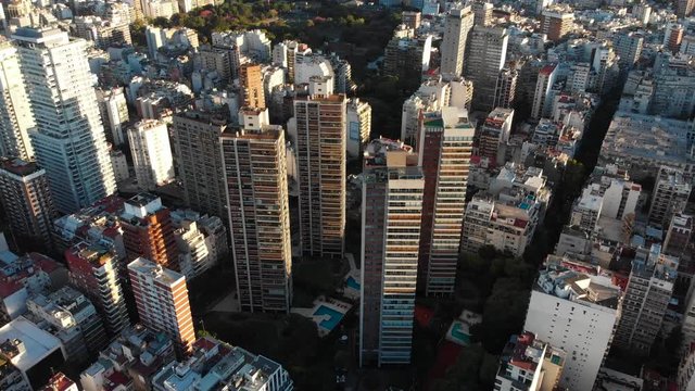 High altitude wide aerial drone view of Palermo and Recoleta Neighborhood in Buenos Aires during sunset with city park and skyscrapers buildings. Warm orange colors. Argentina.