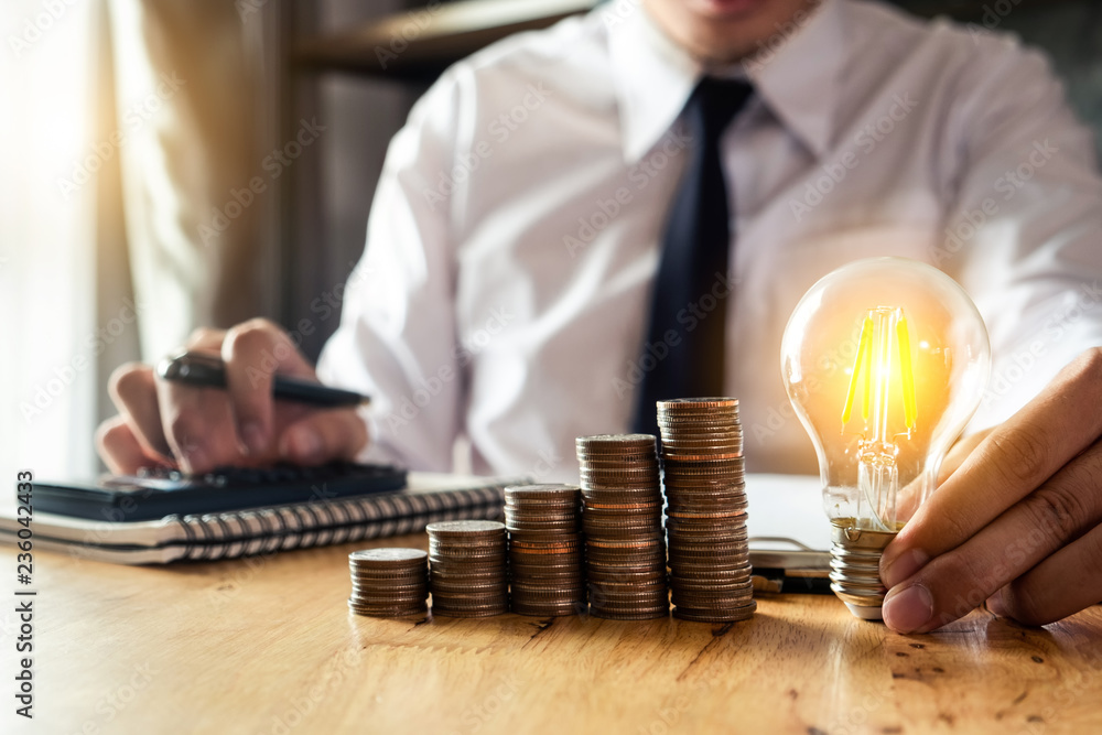 Poster business man hand holding lightbulb with using smartphone and calculator to calculate and money stac