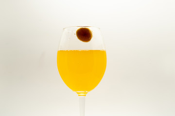 A glass with lemonade on a white background and a slice of banana