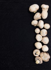 Creative Top view flat lay of fresh raw mushrooms on black background with copy space