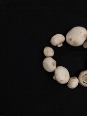 Creative Top view flat lay of fresh raw mushrooms on black background with copy space