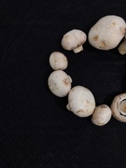 Creative Top view flat lay of fresh raw mushrooms on black background with copy space