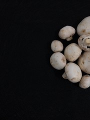 Creative Top view flat lay of fresh raw mushrooms on black background with copy space