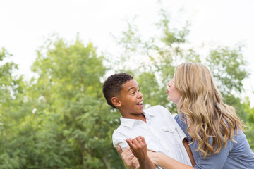 Obraz premium Mother and son laughing and playing at the park.