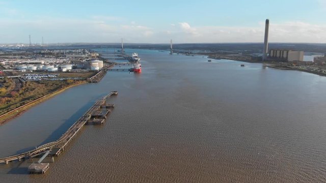 An aerial view of river Thames flying over an empty dock away from the Dartford Crossing