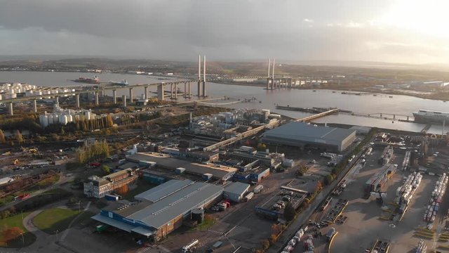 Flying over the industrial area near Dartford Crossing tunnel and Queen Elisabeth II bridge at sunset