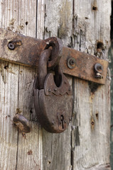 Old rusted lock on a rustic door with decorative natural weathered wood planks