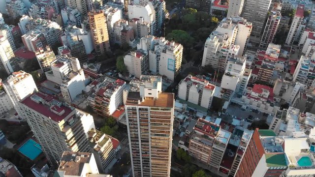 High altitude wide aerial drone view of Palermo and Recoleta Neighborhood in Buenos Aires during sunset with city park and skyscrapers buildings. Warm orange colors. Argentina.