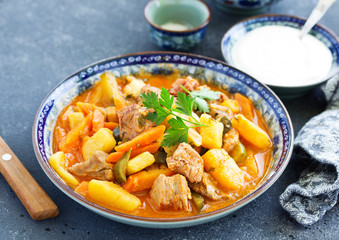 Beef stew with tomato sauce in a pan on wooden background. azu.