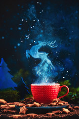 Reindeer figure in a steam over a cup of hot winter drink. Christmas tale concept on a dark...
