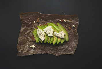 Fresh delicious avocado toast with white cheese. Healthy vegetarian breakfast with rye wholegrain...